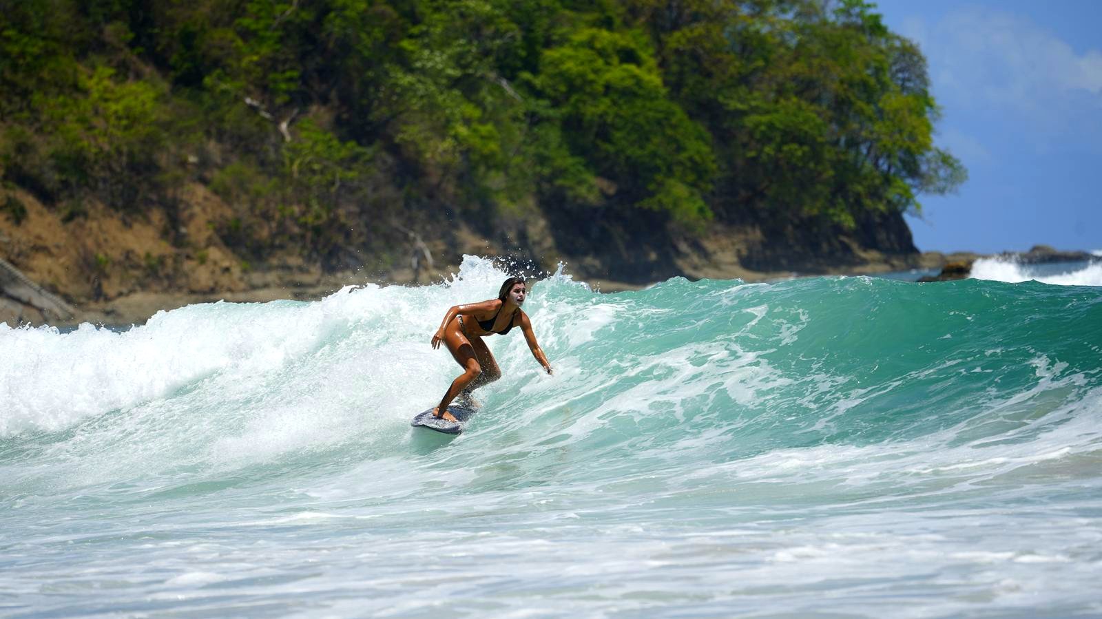 Surfer riding a wave in Jacó